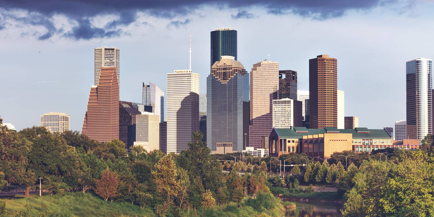 The downtown Houston skyline seen across trees and the bayou