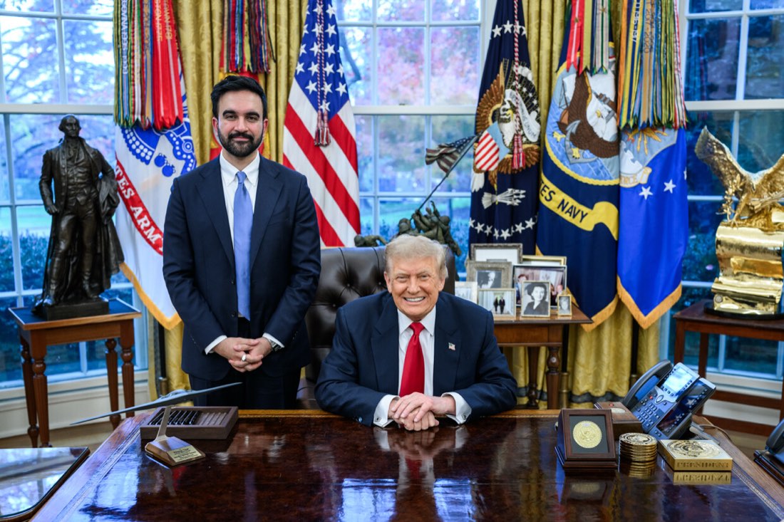 President Trump seated at the Resolute Desk with New York Mayor Zohran Mamdani standing beside him