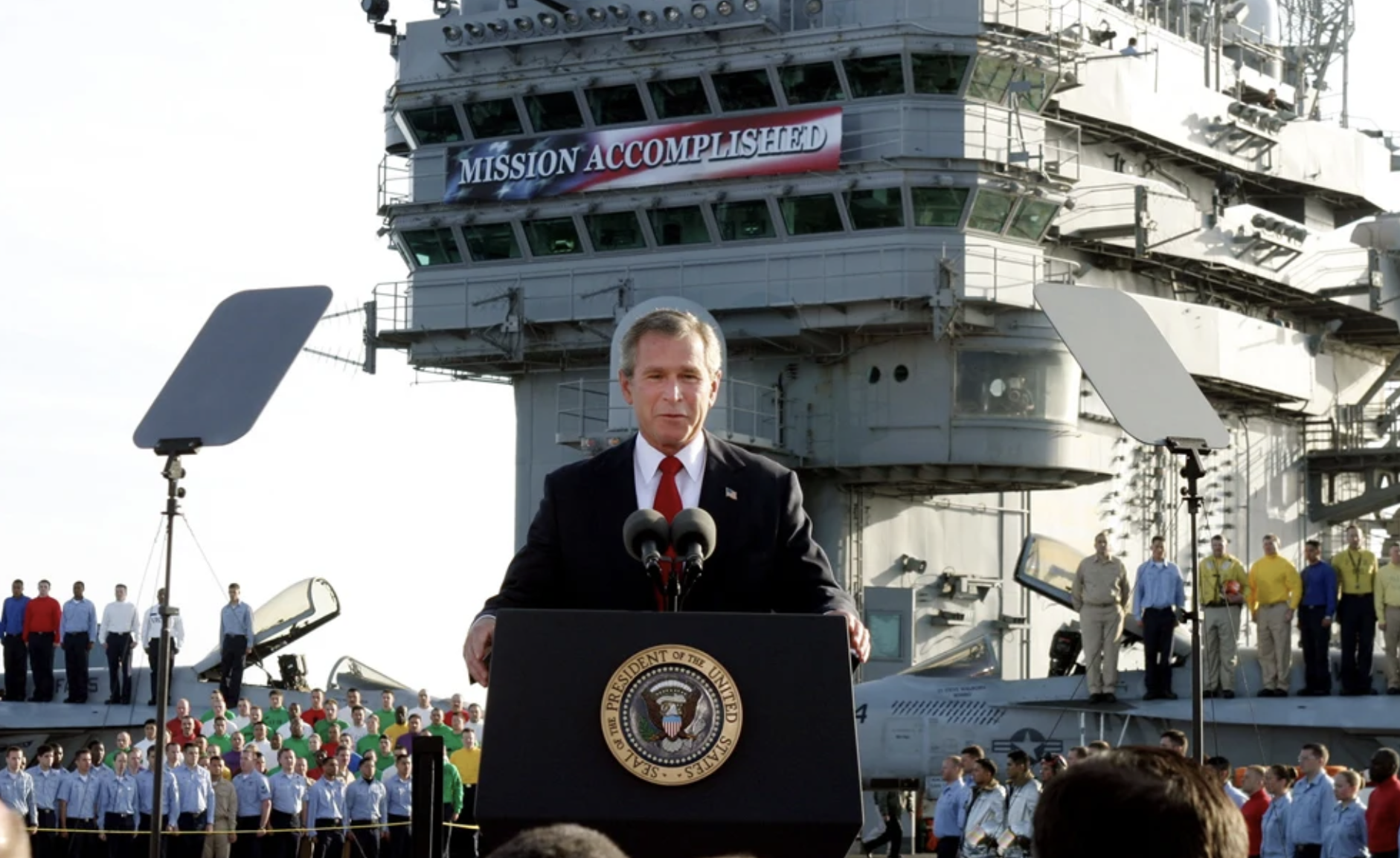 President George W. Bush stands at the podium aboard the USS Abraham Lincoln with the 'Mission Accomplished' banner behind him, May 1, 2003.